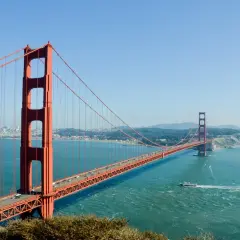 Most znany na świecie, Golden Gate Bridge w San Francisco, z ruchem samochodowym i łodzią na wodzie.