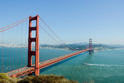 Most znany na świecie, Golden Gate Bridge w San Francisco, z ruchem samochodowym i łodzią na wodzie.